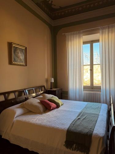 Schlafzimmer mit einem großen Bett und einem Fenster in der Unterkunft Palazzo Lucangeli in Porto Recanati