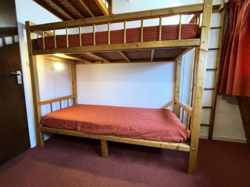 - un lit superposé en bois avec un matelas rouge dans l'établissement Résidence Trois Marches - Studio 2 pers aux pieds des pistes aux Menuires MAE-6154, aux Menuires