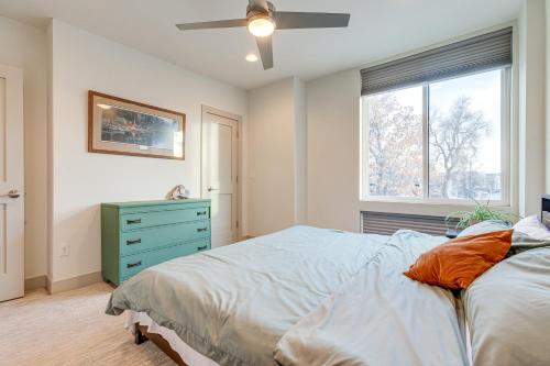 1 dormitorio con 1 cama con cómoda azul y ventana en Modern Townhome with Rooftop Deck - Near City Park!, en Denver