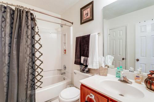 a bathroom with a sink and a toilet and a tub at Georgia Townhome - 3 Mi to Stone Mountain Park! in Stone Mountain