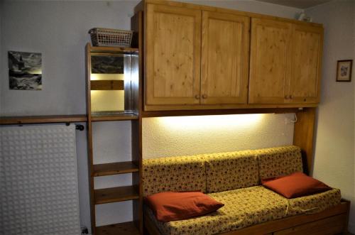a bunk bed with a couch in a room at Résidence Chaviere - Studio pour 2 Personnes 174 in Les Menuires