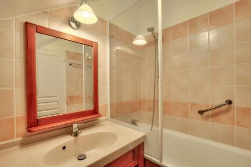 une salle de bain avec un lavabo, un miroir et une baignoire dans l'établissement La résidence du Lac - maeva Home - Maison 2 pièces 5 personnes - Sélection MAE-5764, à Monflanquin
