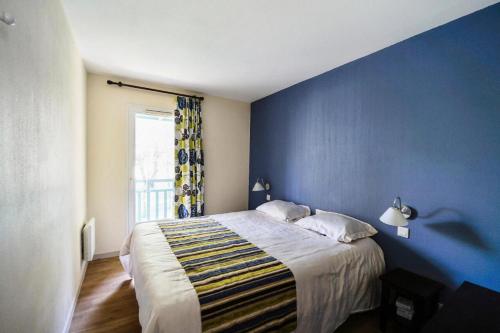 une chambre bleue avec un lit et une fenêtre dans l'établissement Les Maisons du Domaine du Golf de Pinsolle - maeva Home - Maison 3 pièces 6 personnes - Confort MAE-6354, à Soustons