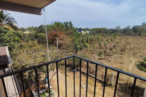 a balcony of a house with a view of a field at Earthy - Vintage in Shimoga