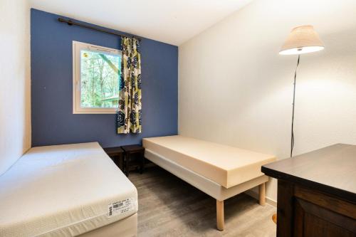 une petite chambre avec deux lits et une fenêtre dans l'établissement Les Maisons du Domaine du Golf de Pinsolle - maeva Home - Maison 3 pièces 6 personnes - Sélection MAE-6364, à Soustons