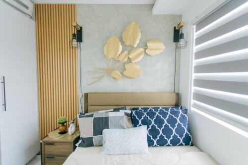 een slaapkamer met een bed met een schilderij aan de muur bij A2J Luxury 2BR Near Il Corso & SM Seaside Cebu in Cebu City