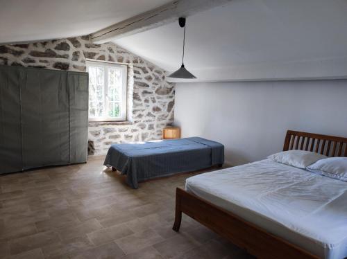 une chambre avec deux lits et un mur en pierre dans l'établissement villa suddard, à La Garde-Freinet