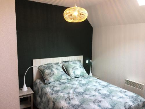 1 dormitorio con cama y lámpara de araña en Résidence Hameau De Balestas Mp - 2 Pièces pour 4 Personnes 924, en Germ