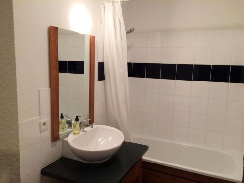 een badkamer met een wastafel, een bad en een spiegel bij Résidence Hameau De Balestas Mp - 2 Pièces pour 4 Personnes 924 in Germ