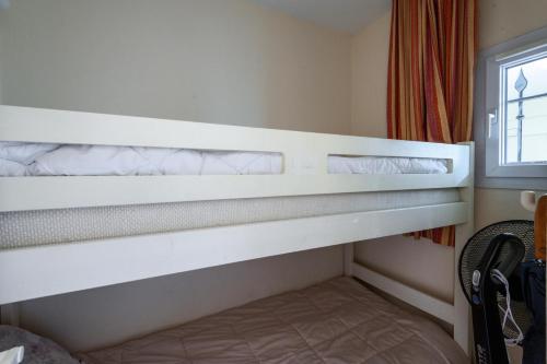 Ce lit superposé se trouve dans un dortoir doté d'une fenêtre. dans l'établissement Village Pont Royal en Provence - maeva Home - Appartement 2 Pièces 6 Personnes - Sélection MAE-0844, à Mallemort