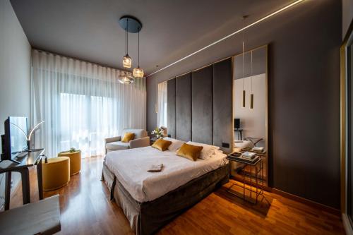 アーバノ・テルメにあるホテル テルメ ミラノのベッドルーム(大型ベッド1台付)、リビングルームが備わります。