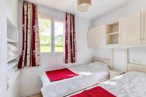 ein Schlafzimmer mit zwei Betten und einem Fenster in der Unterkunft Les maisons Le Rouret - maeva Home - Maison 3 pièces 6 personnes - Sélection MAE-5094 in Grospierres