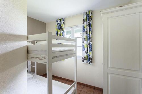 a white bunk bed in a room with a door at Résidence Les Belles Rives - maeva Home - Appartement 2 pièces 5 personnes - Confort MAE-4404 in Argentat