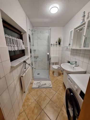 uma casa de banho com um chuveiro, um WC e um lavatório. em Emma em Greifswald