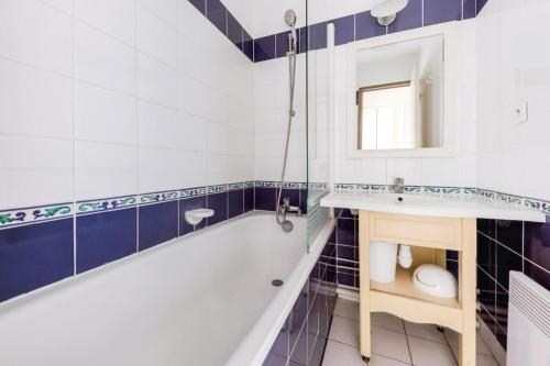 une salle de bain avec une baignoire, un lavabo et un miroir dans l'établissement Port du Crouesty Cap'Océan - maeva Home - Appartement 2 pièces 4 personnes - Sélection MAE-4534, à Arzon