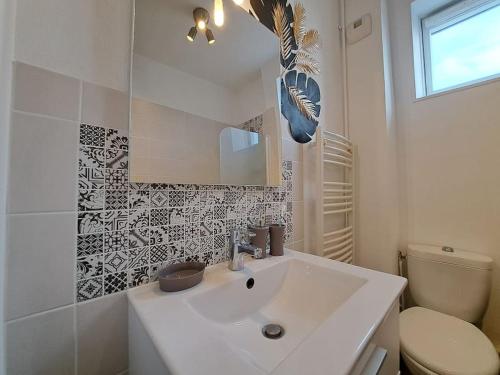 ランスにあるFaro, vue sur la Cathédraleの洗面台とトイレを備えた白いバスルーム