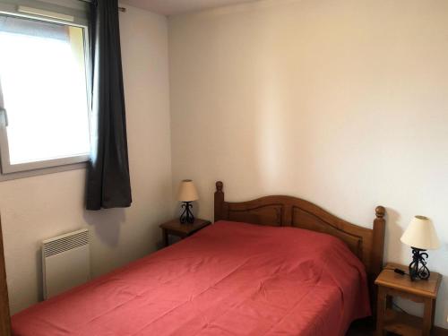 a bedroom with a red bed and a window at Résidence Hameau De Balestas Mp - 2 Pièces pour 6 Personnes 674 in Germ