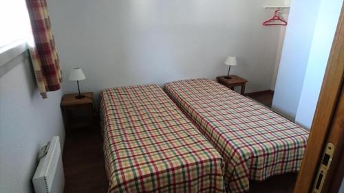 une petite pièce avec un lit et deux lampes sur des tables dans l'établissement Résidence Hameau De Balestas Mp - T3/6pers FORUM 26- Peyresourde MAE-4694, à Germ