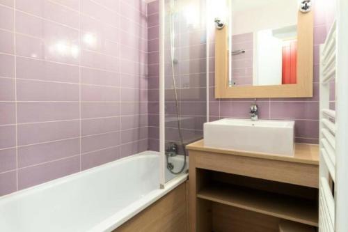 une salle de bain avec une baignoire, un lavabo et un miroir dans l'établissement Village Moliets - maeva Home - Appartement 2 pièces 4 personnes - Confort MAE-6784, à Moliets-et-Maa