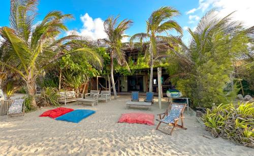 a beach with chairs and palm trees and a building at 3 Piratas in Prea