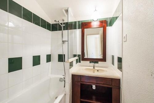 une salle de bain avec un lavabo, un miroir et une baignoire dans l'établissement Le Domaine du Golf de Pinsolle - maeva Home - Appartement 2 pièces 6 personnes - Confort MAE-9354, à Soustons