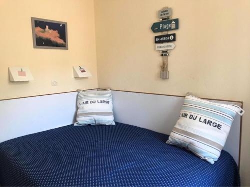 - une chambre avec un lit bleu et 2 oreillers dans l'établissement Résidence le Hameau de Cap Esterel - maeva Home - Appartement 2 pièces 4 personnes - Sélection MAE-0594, à Saint-Raphaël
