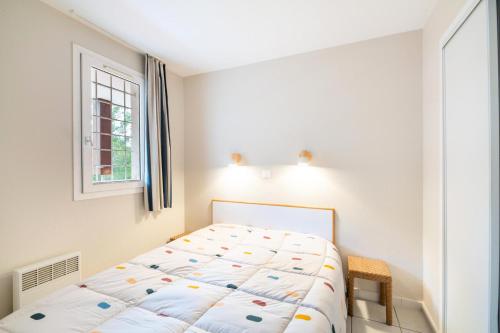 une chambre avec un lit et une fenêtre dans l'établissement Résidence le Hameau de Cap Esterel - maeva Home - Appartement 3 pièces 7 personnes avec vue mer - Prestige MAE-6934, à Saint-Raphaël