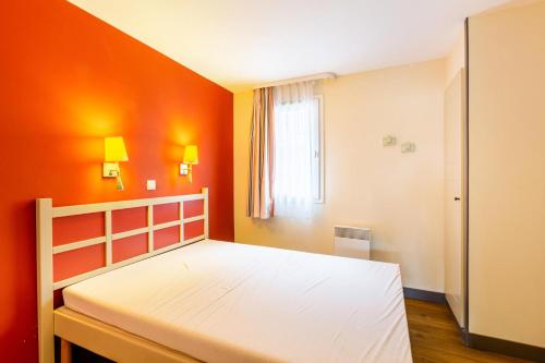 - une chambre avec un lit blanc aux murs orange dans l'établissement Résidence le Village de Cap Esterel - maeva Home - Appartement 2 pièces 4 personnes - Confort MAE-6794, à Saint-Raphaël
