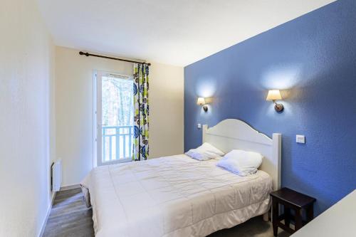 une chambre bleue avec un lit et une fenêtre dans l'établissement Les Maisons du Domaine du Golf de Pinsolle - maeva Home - Maison 3 pièces 6 personnes - Sélection MAE-9804, à Soustons