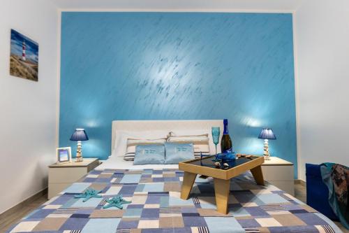 サン・ヴィート・ロ・カーポにあるCasa Vacanze Il Faro San Vito Lo Capo-Trapani-Sicilia Ovest Holiday Homeの青い壁のベッドルーム1室