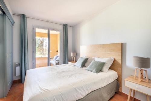 - une chambre avec un grand lit blanc et des rideaux bleus dans l'établissement Résidence Hôtel du Golf de Pont Royal - maeva Home - Appartement climatisé ravissant 2 pièces 4 personnes - Prestige - super Home MAE-3104, à Mallemort