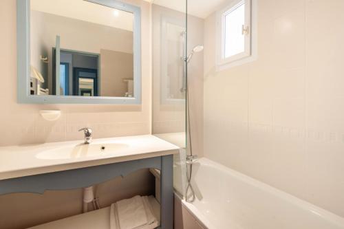 une salle de bain avec un lavabo, un miroir et une baignoire dans l'établissement Résidence Hôtel du Golf de Pont Royal - maeva Home - Appartement climatisé ravissant 2 pièces 4 personnes - Prestige - super Home MAE-3104, à Mallemort