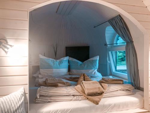 een slaapkamer met een bed en een groot raam bij Tiny Igloo Elrond in Belau