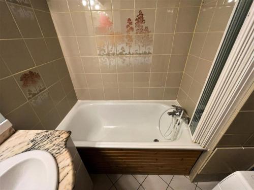 une salle de bain avec baignoire et toilettes dans l'établissement Résidence Tougnette - Appartement pour 4 personnes avec balcon exposé Sud MAE-6864, aux Menuires