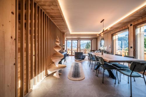 ein Esszimmer mit einem langen Tisch und Stühlen in der Unterkunft Chalet Bellatrix Morzine - by EMERALD STAY in La Côte dʼArbroz