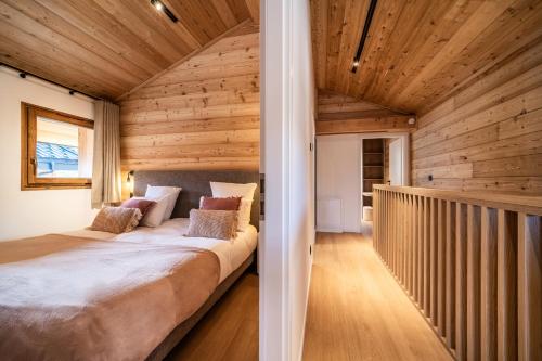 Cette chambre en bois comprend un grand lit. dans l'établissement Chalet Bellatrix Morzine - by EMERALD STAY, à La Côte dʼArbroz
