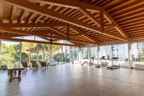 a large room with a gym with a lot of windows at Hotel Terme Milano in Abano Terme