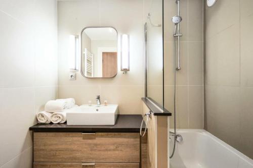 une salle de bain avec un lavabo, une baignoire et un miroir dans l'établissement Résidence Presqu'Ile de la Touques - Appartement 3 pièces 6 personnes - Exclusive MAE-5334, à Deauville