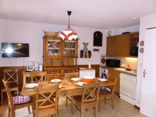 une cuisine avec une table et des chaises de salle à manger en bois dans l'établissement Résidence Les Cimes D'or A - Cîmes d'Or A28 MAE-6344, aux Contamines-Montjoie