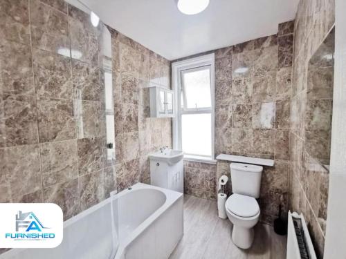 a bathroom with a tub and a toilet and a sink at 4 Bedroom House - Contractors Welcome in Scarborough