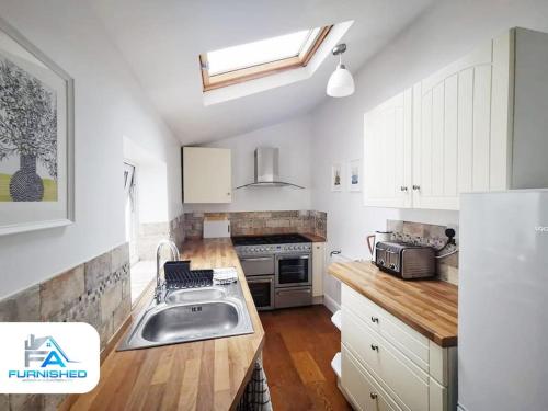 a kitchen with a sink and a stove at 4 Bedroom House - Contractors Welcome in Scarborough