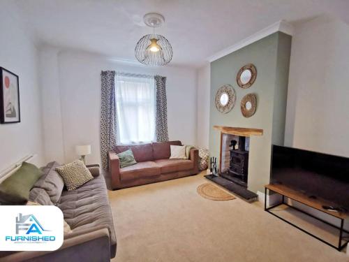 a living room with a couch and a fireplace at 4 Bedroom House - Contractors Welcome in Scarborough