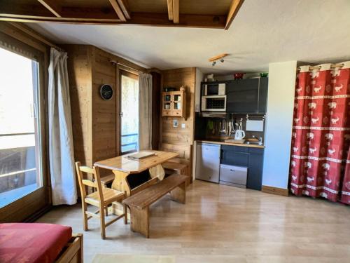 a small kitchen with a wooden table and chairs at Résidence Curling A2 - Studio pour 3 Personnes 064 in Tignes