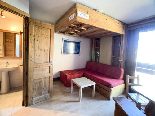 a living room with a red couch and a sink at Résidence Curling A2 - Studio pour 3 Personnes 064 in Tignes