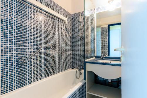 une salle de bain avec une baignoire et un lavabo et une baignoire tubermottermott dans l'établissement Résidence Port Bourgenay - maeva Home - Studio 4 personnes - Sélection MAE-0364, à Talmont-Saint-Hilaire