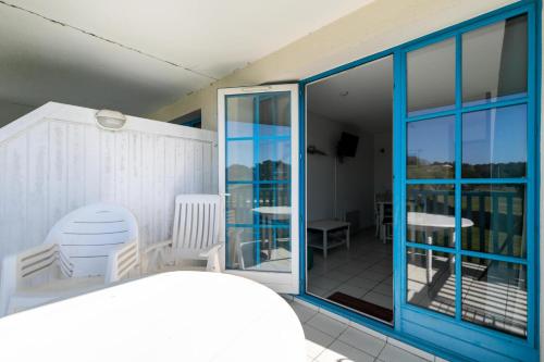 Cette chambre dispose d'un balcon avec des chaises et une porte en verre. dans l'établissement Résidence Port Bourgenay - maeva Home - Studio 4 personnes - Sélection MAE-0364, à Talmont-Saint-Hilaire
