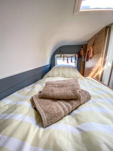 a bedroom with a bed with two towels on it at George Glamper KÜSTENKIND in Belau