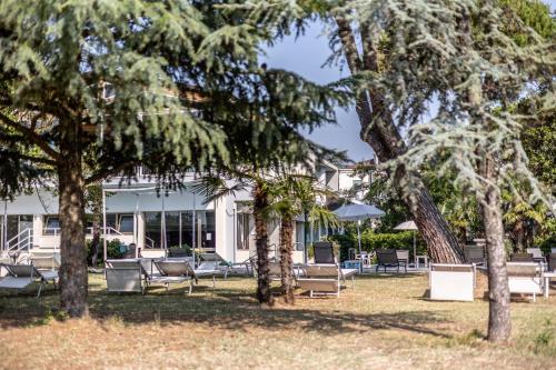 a house with chairs and trees in the yard at Hotel Terme Milano in Abano Terme