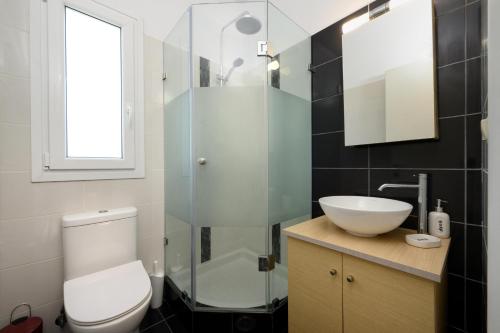 y baño con aseo, lavabo y ducha. en Aliki`s Luxury Suite with view, pet friendly! en Vátos