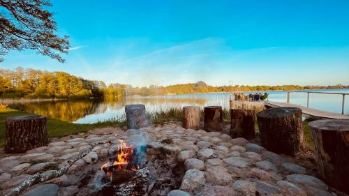 a fire pit next to a body of water at George Glamper KÜSTENKIND in Belau